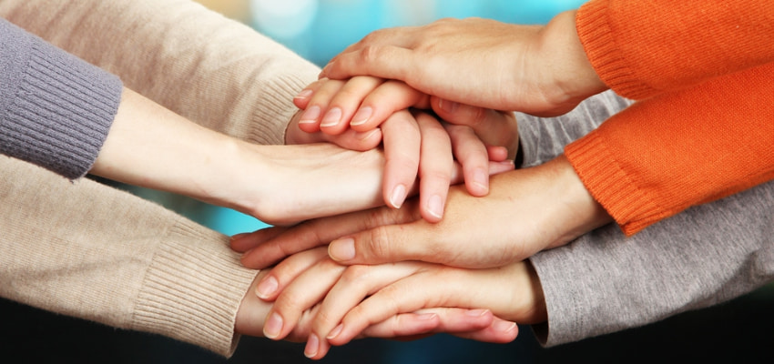 coworkers stack hands during a Los Angeles team building event