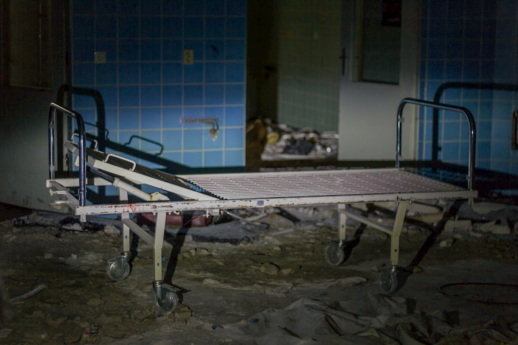 Abandoned hospital bed in dark room