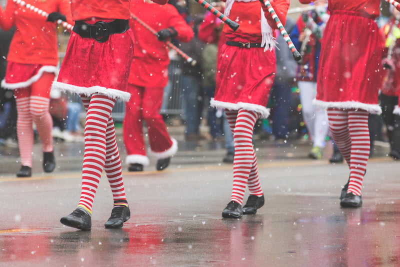 parade performers in red and white striped tights march through los angeles at the hollywood christmas parade