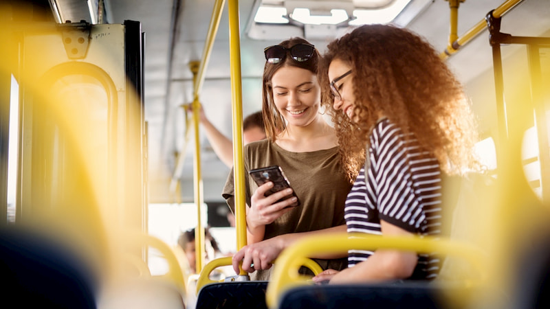 passengers laugh and stand on public transportation in Los Angeles