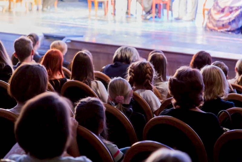 patrons look towards a theatre stage during a production of Hamilton