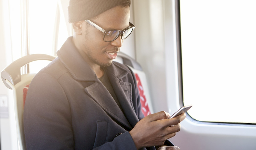 a businessman uses a cell phone on a charter bus in Los Angeles California