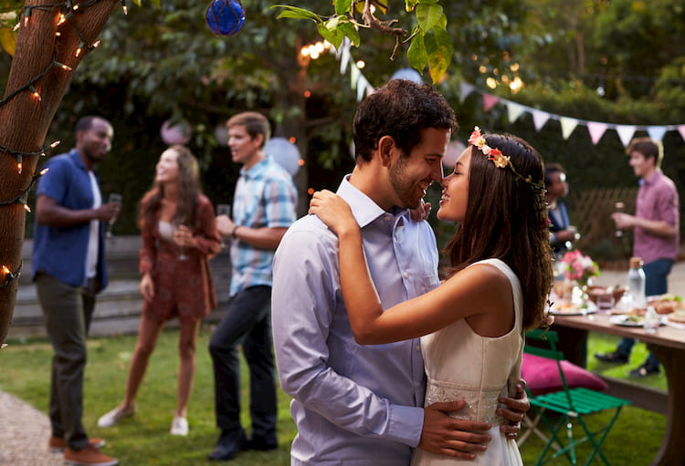 Bride and groom kissing in casual wedding attire at outdoor wedding