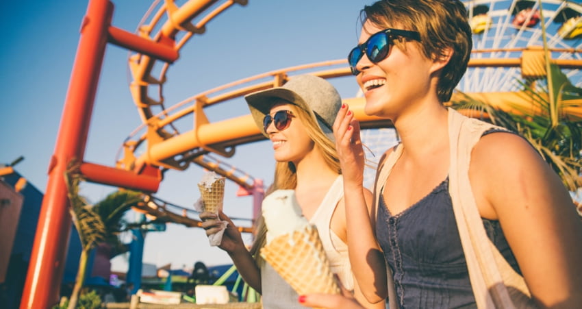 two women eat ice cream and laugh on the Santa Monica Pier