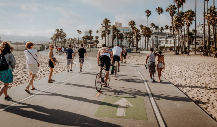 Pedestrians bike and walk on the beach in Venice, California