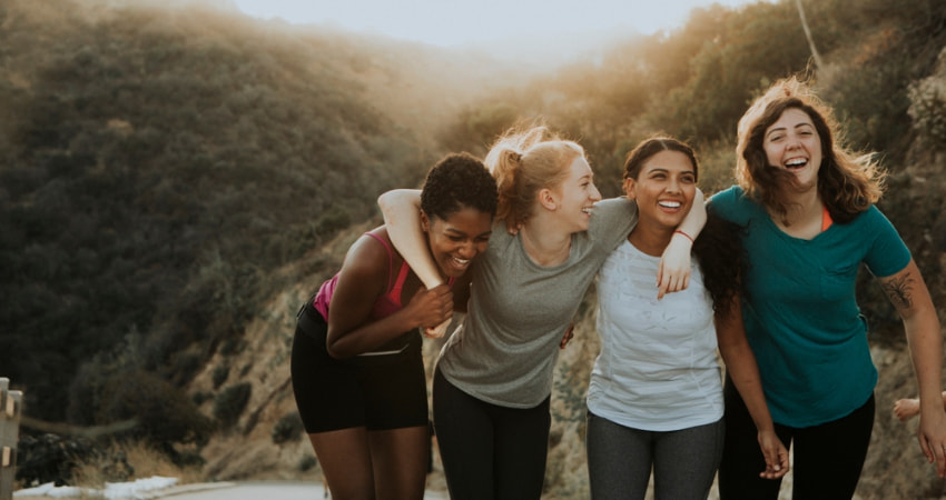 A group of women laugh as they hike up Mount Baldy