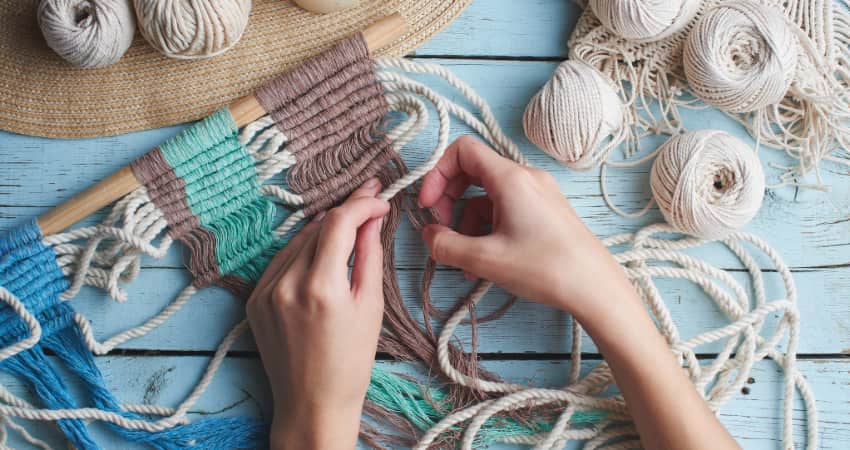 a crafter makes a wall-hanging out of rope and twine