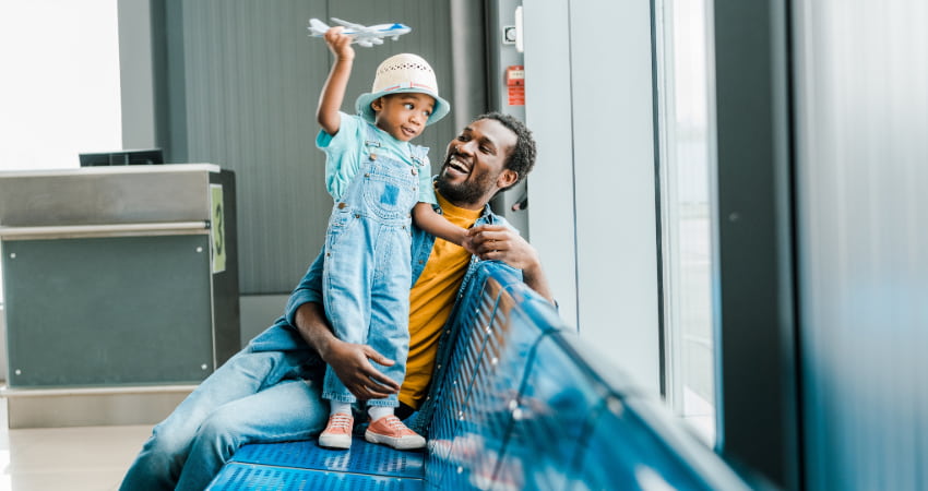 a father and son laugh and play in an airport