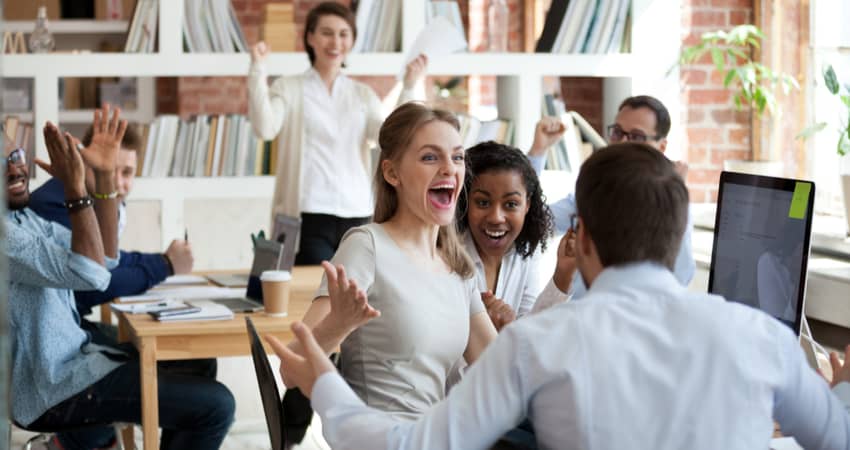 A group of excited colleagues clapping