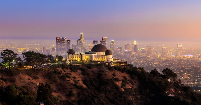 The Griffith Observatory at sunset, the Los Angeles skyline in the distance