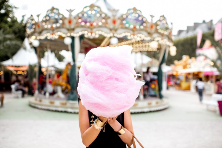 A person is posing with pink cotton candy