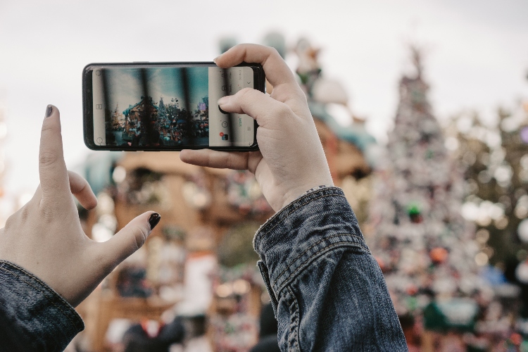 A person is snapping a picture of Disneyland with their phone