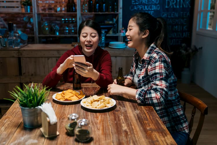 Young women drinking beer at bar