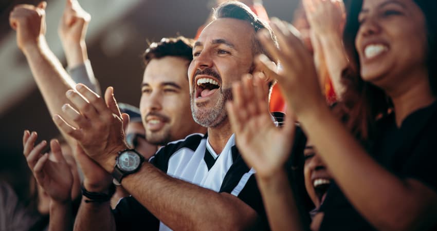 A group of sports fans cheering at a game