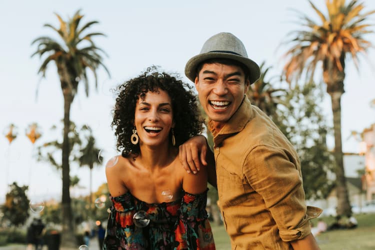 Woman and man outside in front of palm trees