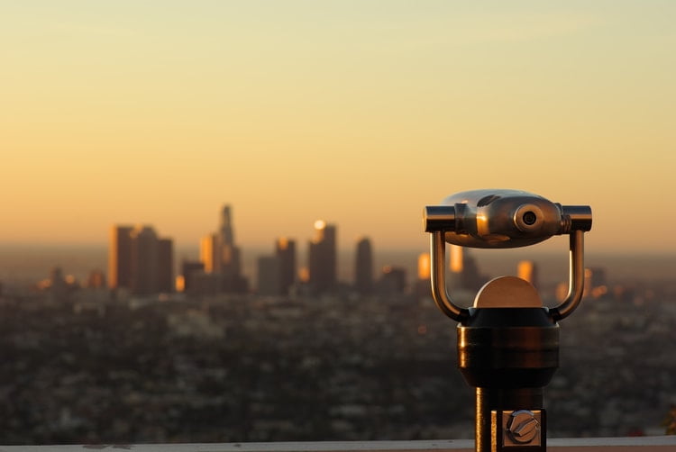 a telescope looking over a city center at dusk