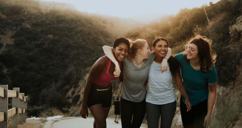 A group of friends smiling and hugging on a beach