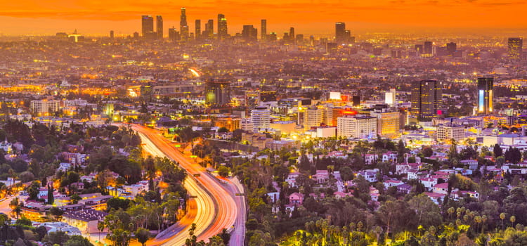 the los angeles skyline at sunset with an orange sky in the background
