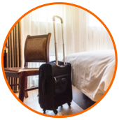 a chair and rolling suitcase in a hotel room